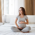 mujer embarazada sonriente sentada cama portada TPNI Plus